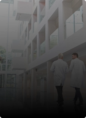 Two medical professionals walking inside a bright, modern healthcare facility, representing American Security Force's specialized medical security services.