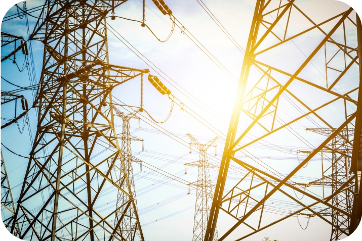 High-voltage transmission towers and power lines at sunset, symbolizing utility infrastructure security and grid protection by American Security Force.


