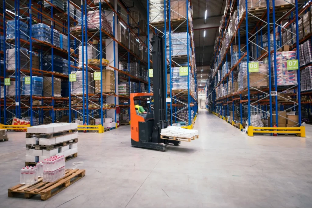 Forklift operating inside a large warehouse with organized inventory racks, highlighting warehouse security guard patrol and asset protection services by American Security Force.