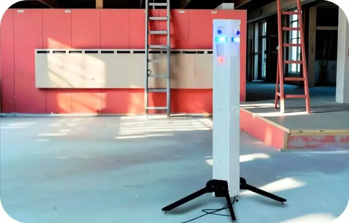 A white, tall Sentinel mobile surveillance tower with glowing blue and orange lights, set up indoors at an industrial site, demonstrating rapid-deployment site security capabilities.