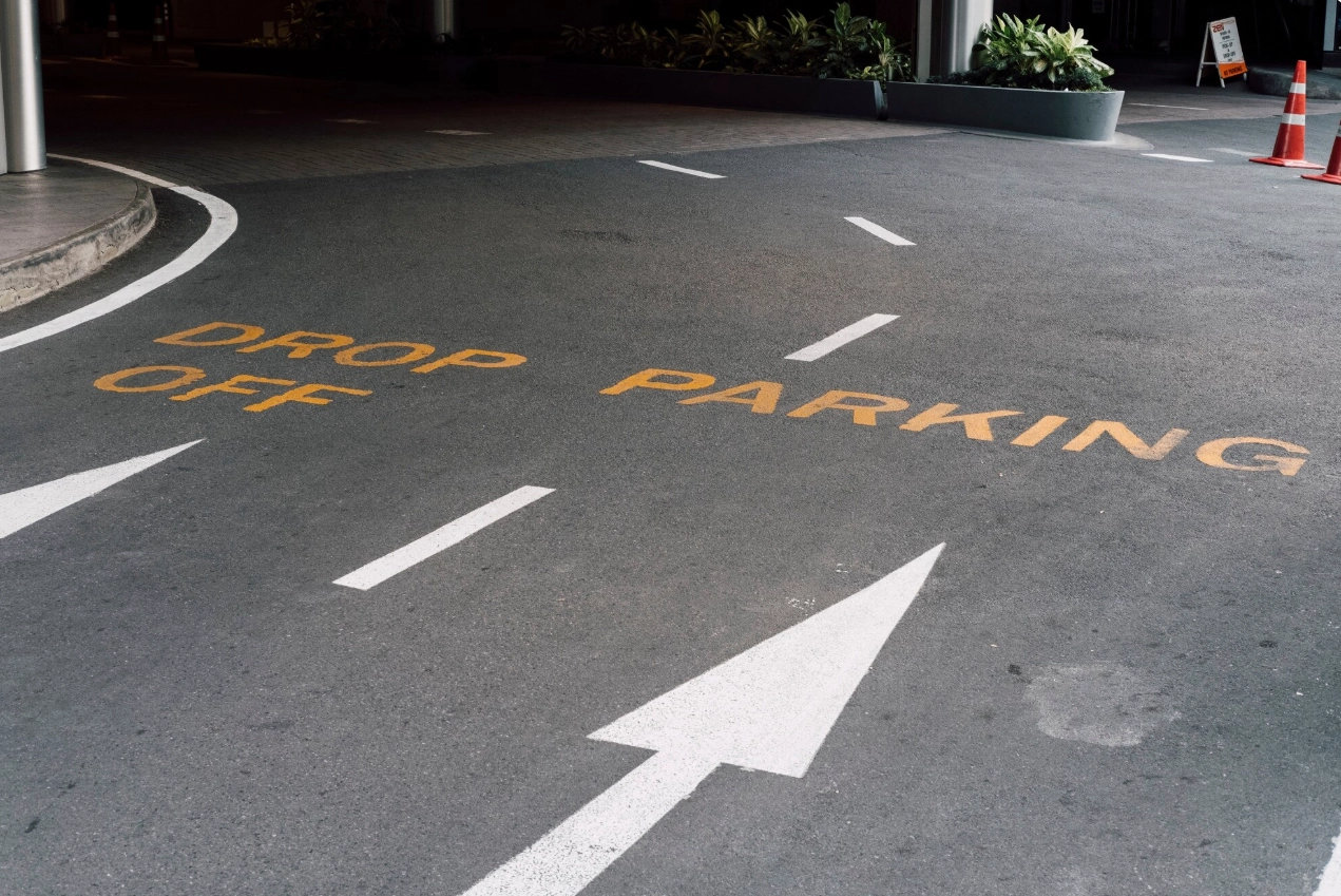 Clearly marked drop-off and parking area in a commercial parking lot with directional signage, supporting traffic flow and safety.