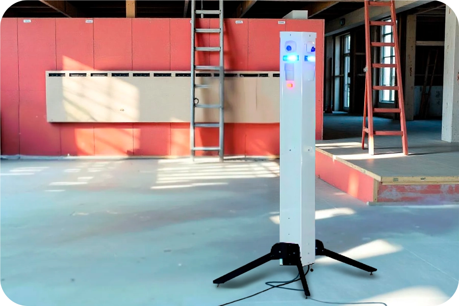 Sentinel Mobile Surveillance Tower for Remote Site Security A white, tall Sentinel mobile surveillance tower with glowing blue and orange lights, set up indoors at what appears to be a construction or industrial site, demonstrating rapid-deployment site security capabilities.