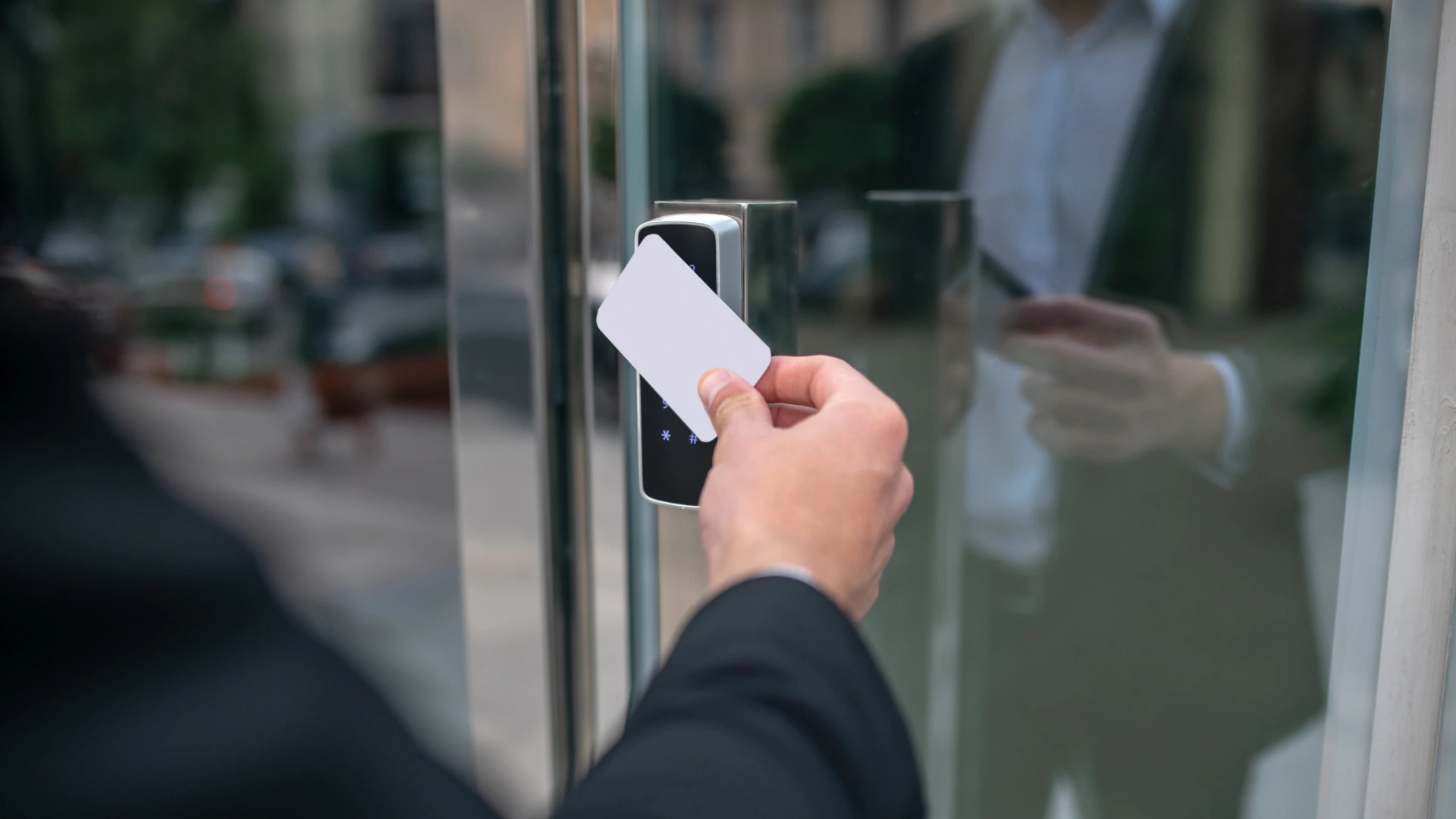 Person using a key card for secure entry into a building, using an access control system