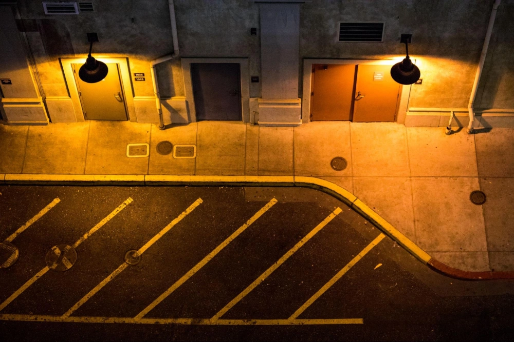 Nighttime view of a commercial property exterior and parking area, highlighting the need for professional security patrol by American Security Force