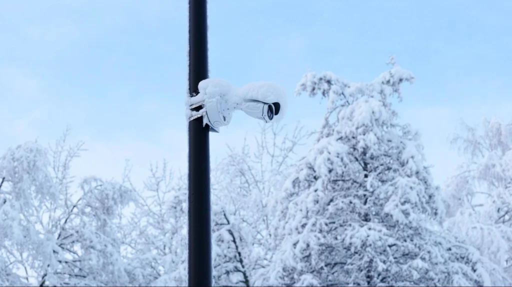 Outdoor security camera covered in snow during winter, highlighting the importance of weather-resistant surveillance systems
