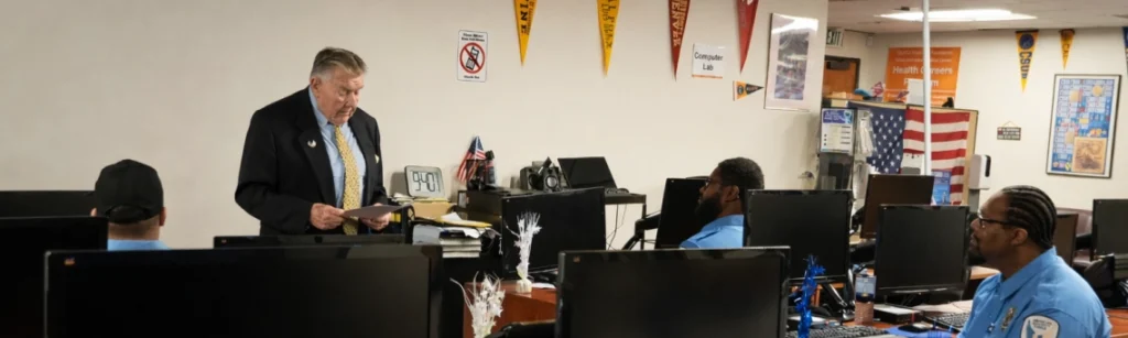 American Security Force instructor leading security guard training session in classroom with officers at computers