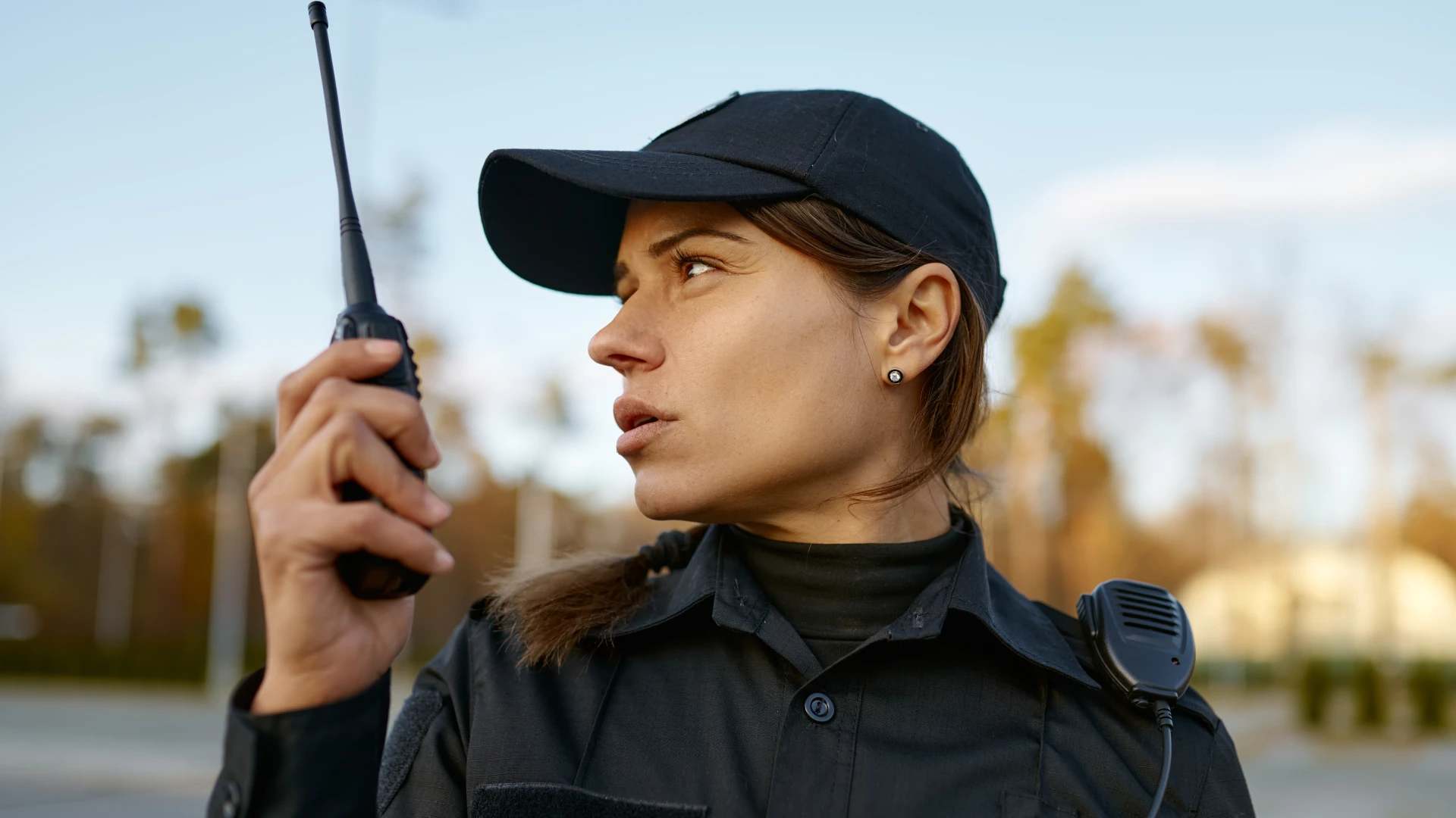 A female security officer holding a walkie talkie, showcasing the different types of patrolling